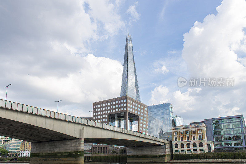 the Shard building and the London Bridge over the Thames river at the City of London, England, UK.英国伦敦金融城的碎片大厦顶部和横跨泰晤士河的伦敦桥。